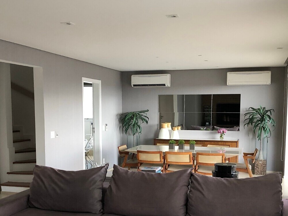 Sala integrada com dois ar-condicionados de parede instalados no topo da parede ao fundo
